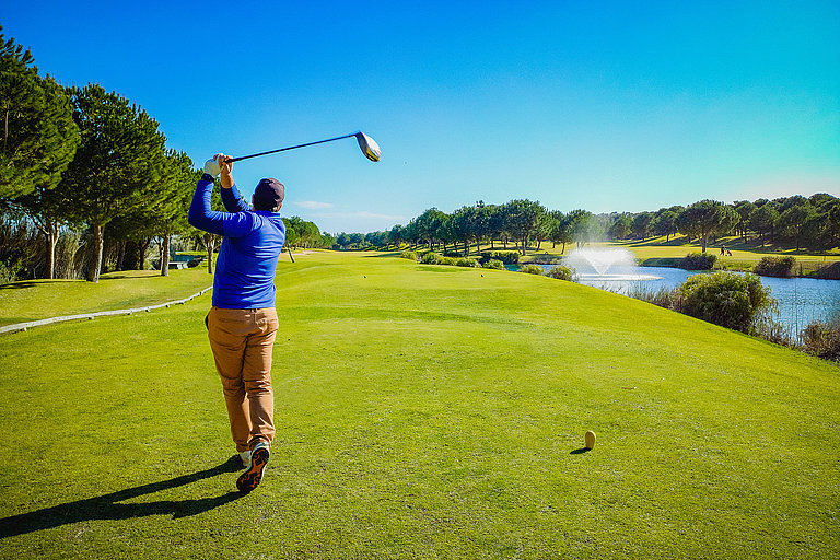Golfer auf einem Golfplatz bei Quinta do Lago mit Fairway und blauem Himmel.