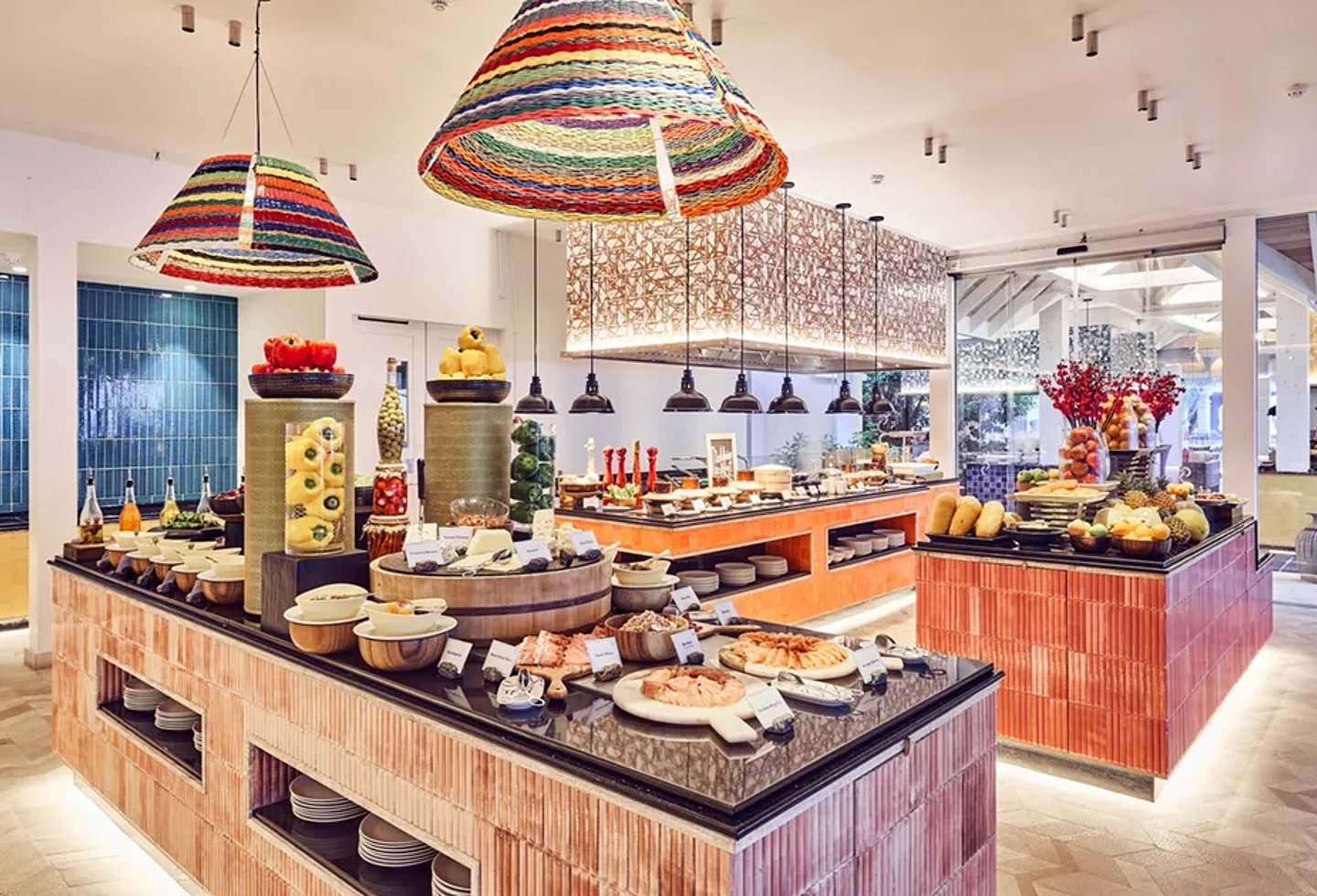 Buffetrestaurant mit großer Speisenauswahl, Holztresen und bunten Hängelampen.