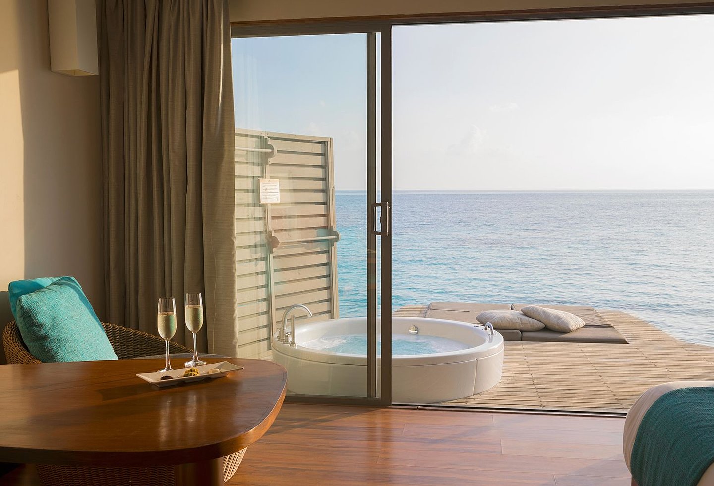 Blick aus dem Hotelzimmer auf die Outdoor Wanne und das Meer der Malediven.