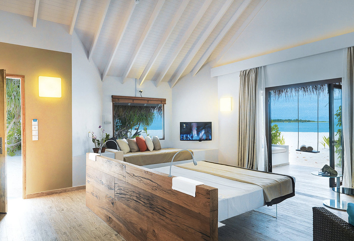 Helle Beach Suite mit großem Bett und minimalistischem, tropischem Design.
