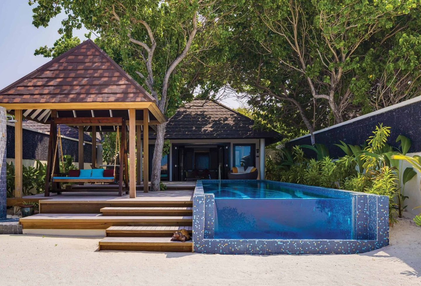 Blick vom Strand auf privaten Pool, Terrasse mit Hängeschaukel hin zur Villa.