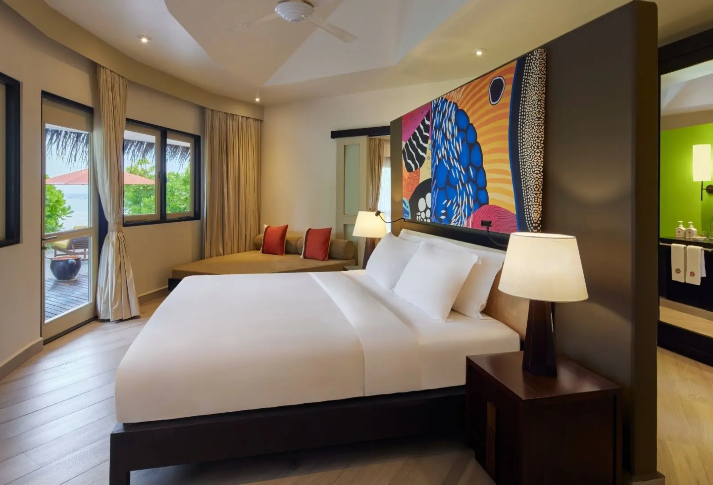Modernes, helles Schlafzimmer mit Doppelbett, buntem Wandbild und großen Fenstern.