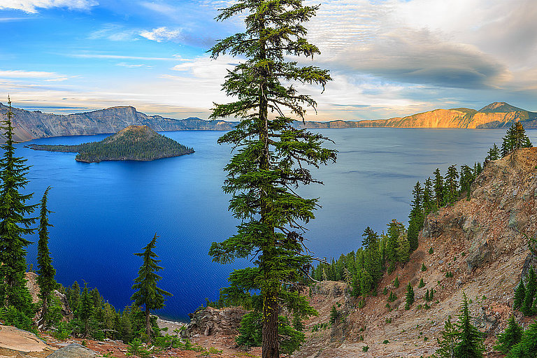 Panoramablick auf den Crater Lake in Oregon mit blauem See und bewaldeter Landschaft.