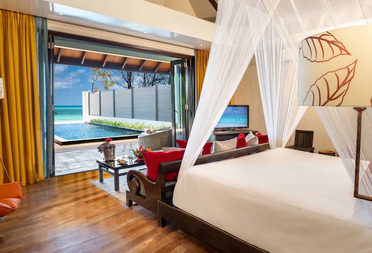 Helles Schlafzimmer mit Himmelbett, Holzdetails und direktem Blick aufs Meer.