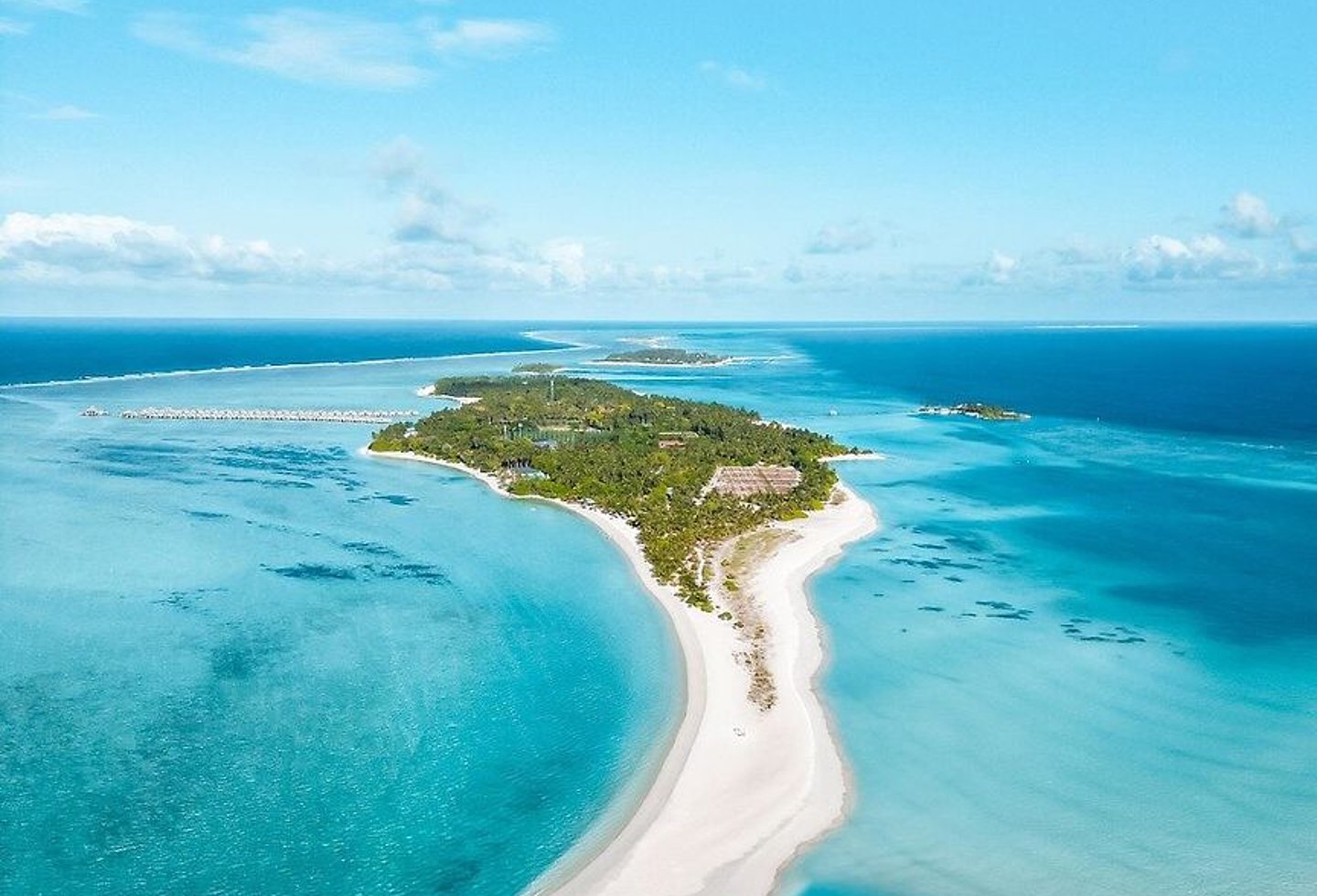 Überwasserbungalows am türkisfarbenen Meer mit weißen Sandstränden.