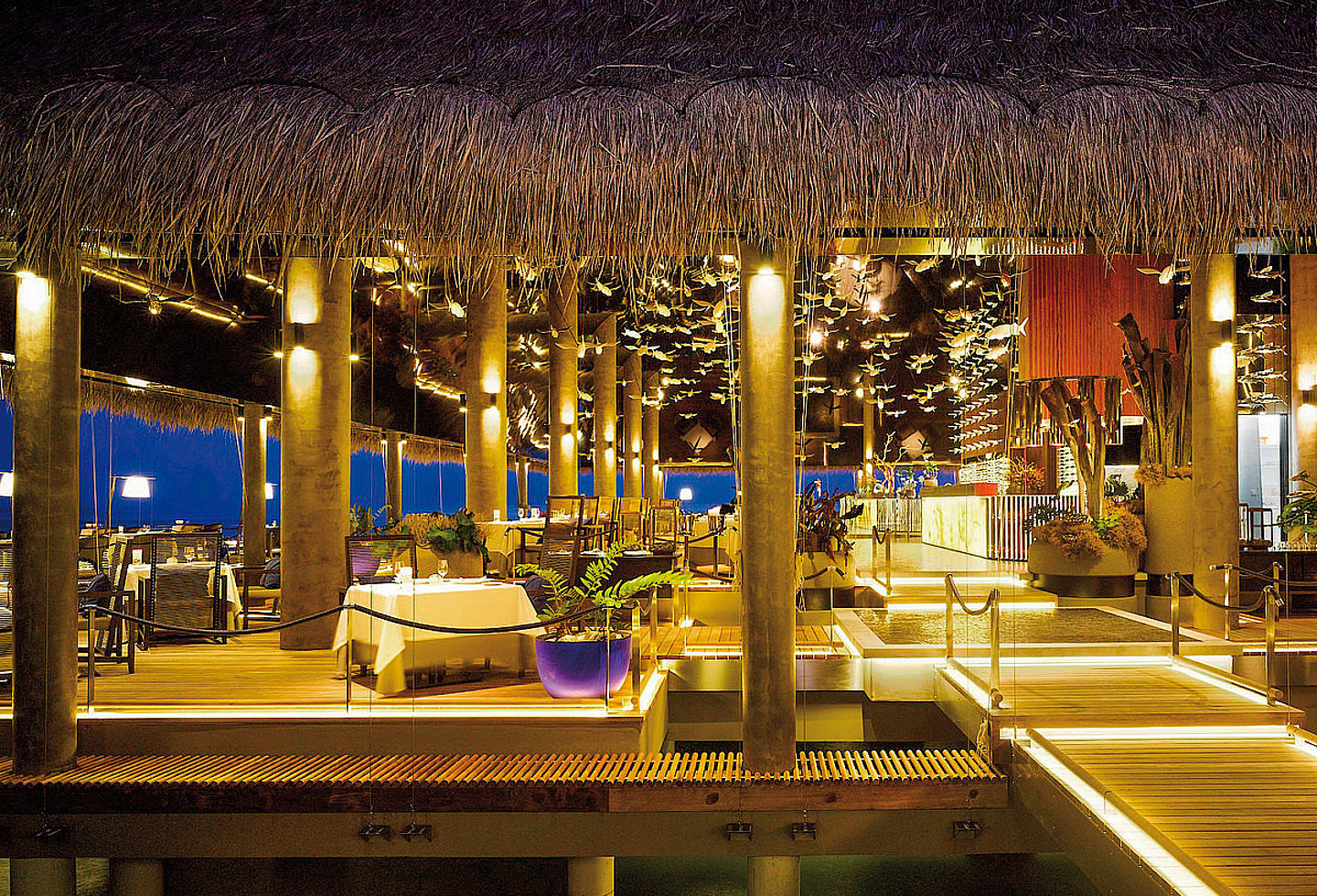 Beleuchtetes Restaurant mit modernem Interieur und eleganter Atmosphäre.