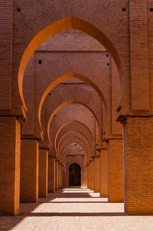 Das Bild zeigt die roten Ziegelbögen der Moschee von Tinmal in Marokko.