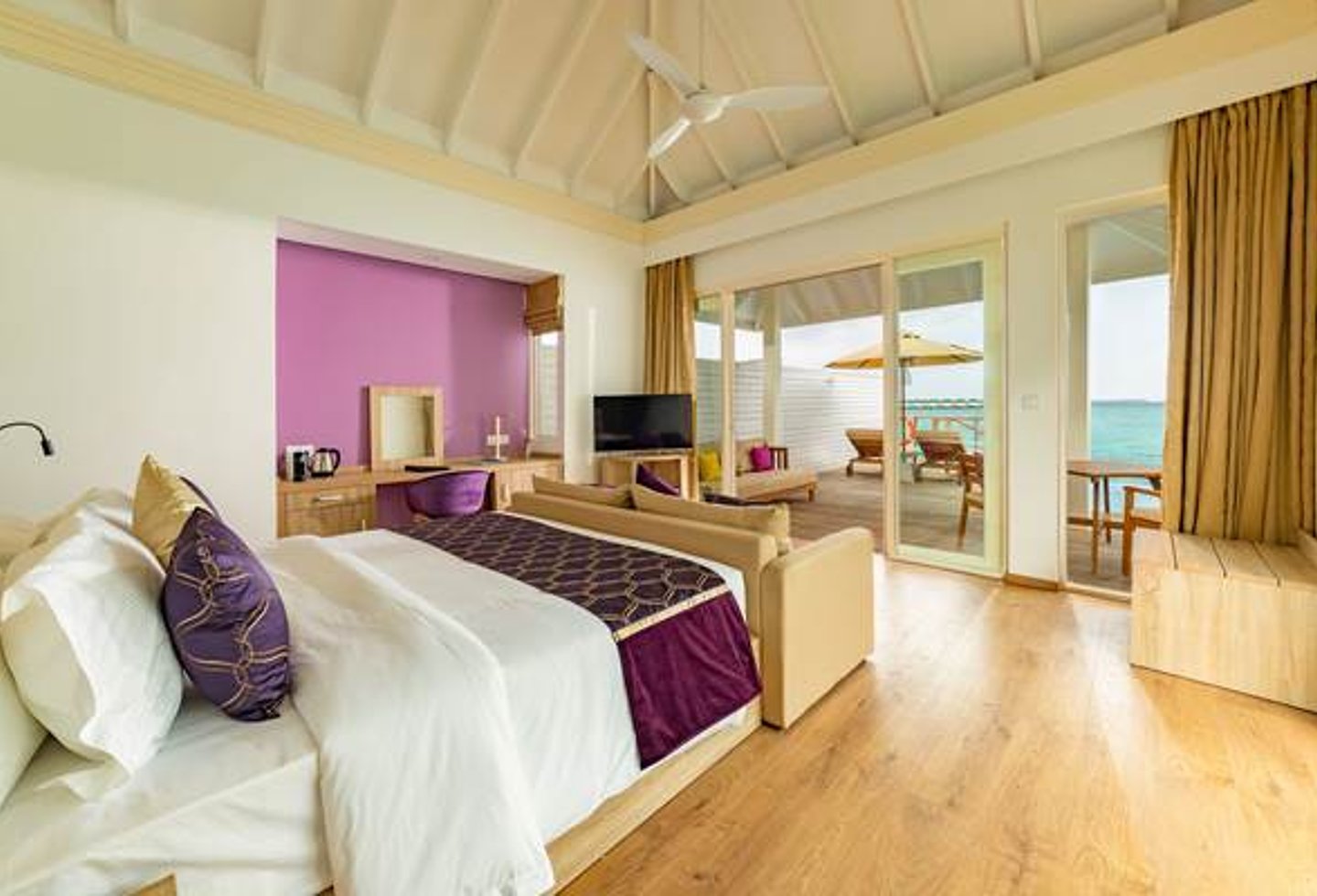 heller Schlafraum, Dekor in rosa und lila, große Fensterfront, Blick auf Terrasse und das Meer