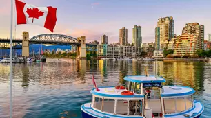 Vancouver mit kanadischer Flagge, Booten, Skyline und Hafenblick bei Abendlicht.