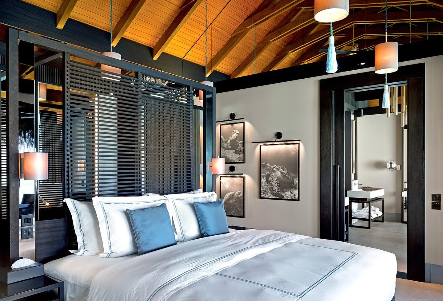 Luxuriöses Schlafzimmer mit Blick auf den Pool und tropische Vegetation.
