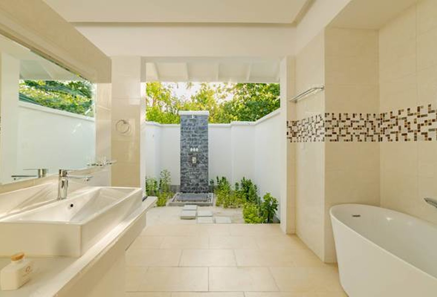 sehr helles Badezimmer in weiß und beige, Blick nach draußen zur Outdoor Dusche