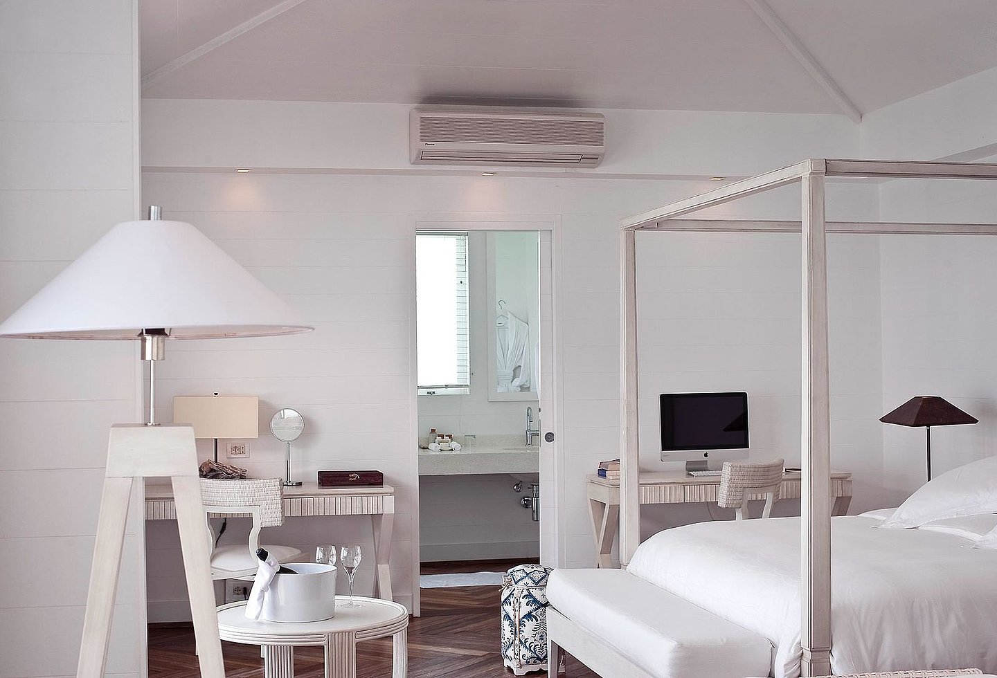 Moderne, weiß eingerichteter Wohnbereich mit Himmelbett und Blick auf das Wasser.