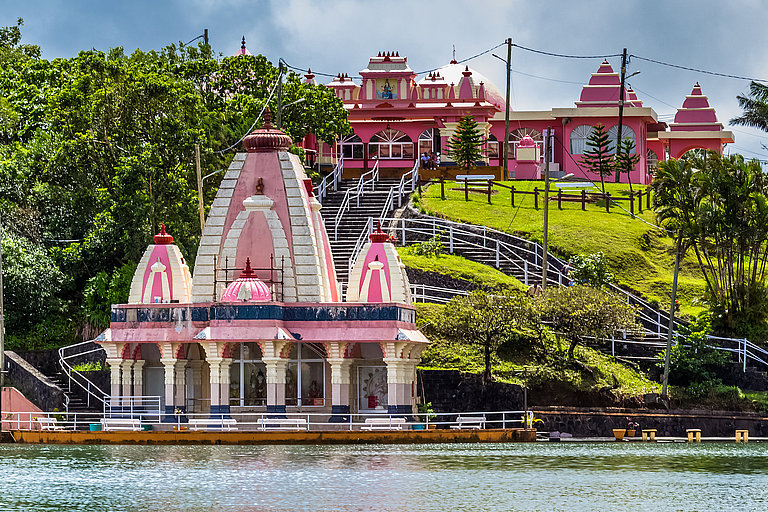 Hinduistischer Tempel am Grand Bassin auf Mauritius mit bunten Gebäuden am See.