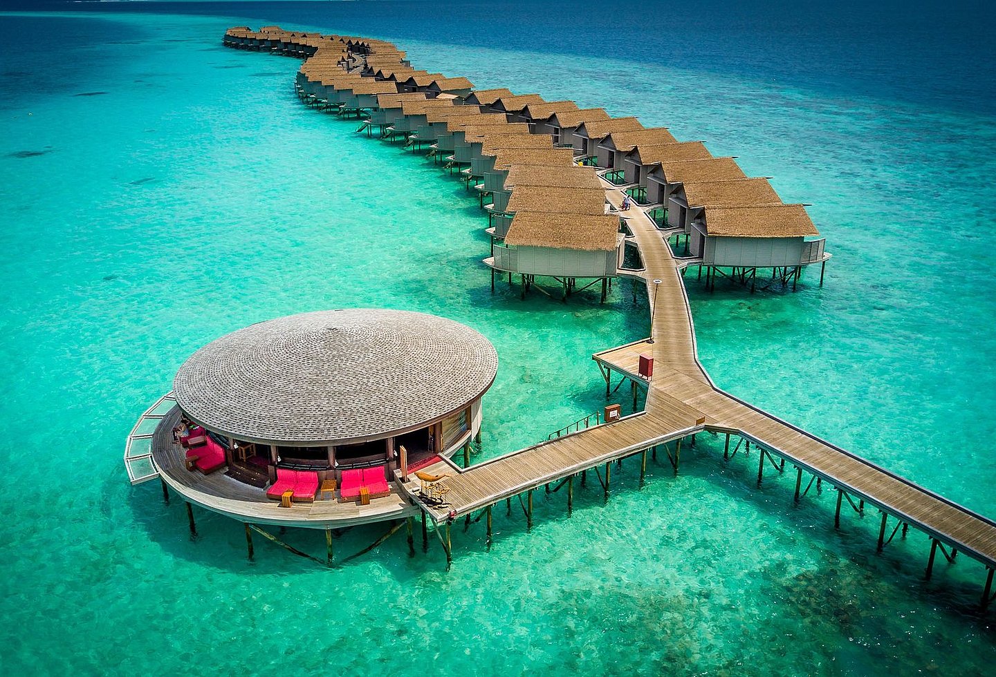 Steg mit kleinen Wasserbungalows des Centara Ras Fushi Resort & Spa Maldives.
