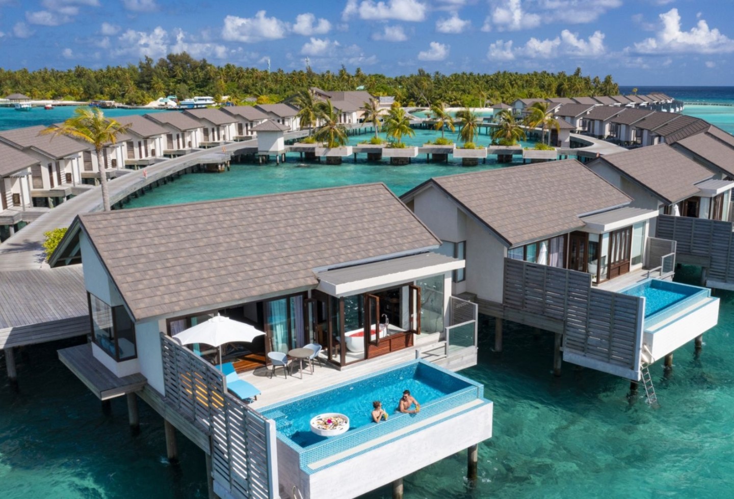 Weiße Wasservilla am Steg mit privatem Pool zum Meer hin und freistehender Badewanne.