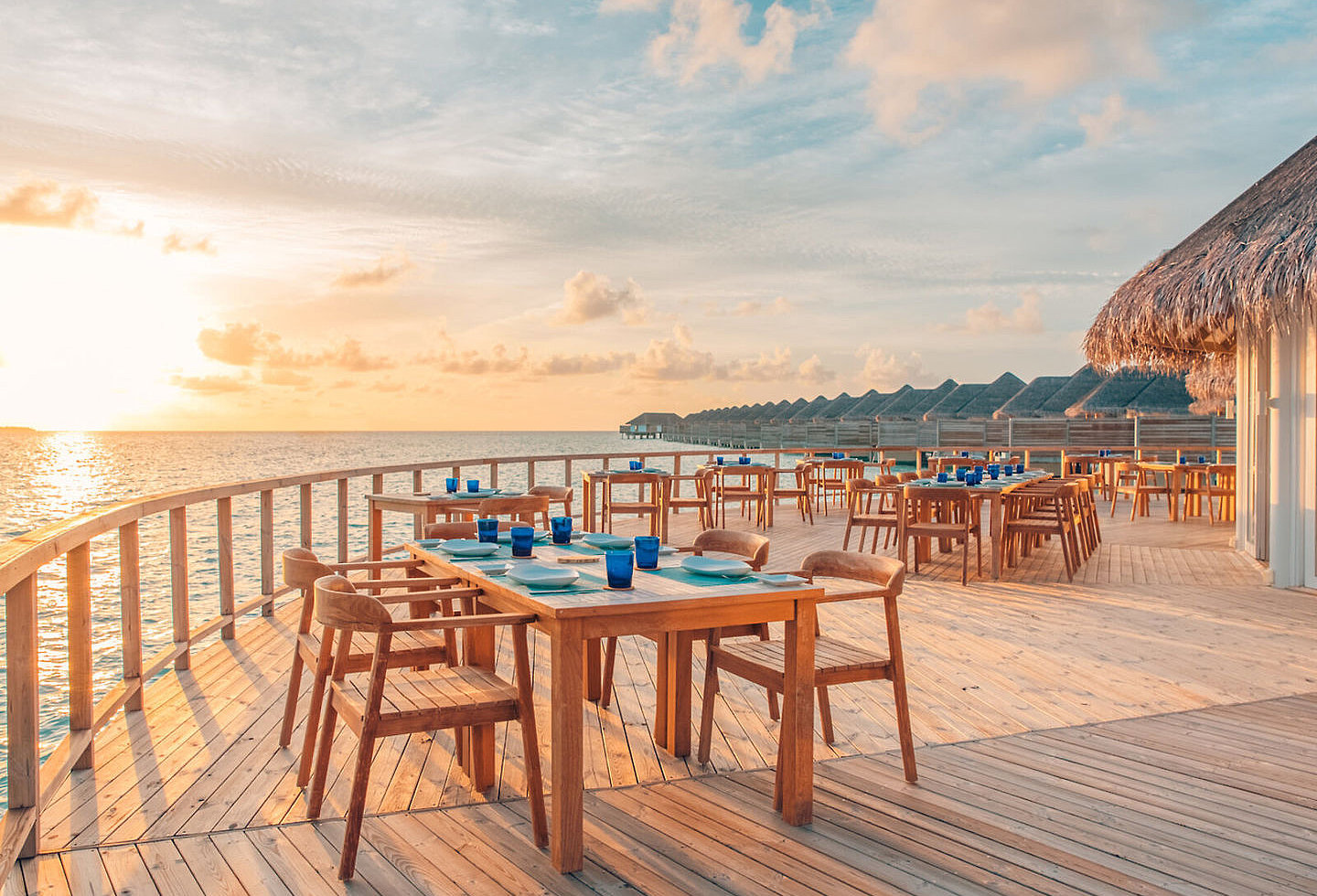 Große Terrasse eines Restaurants, gelegen am Meer bei Sonnenuntergang