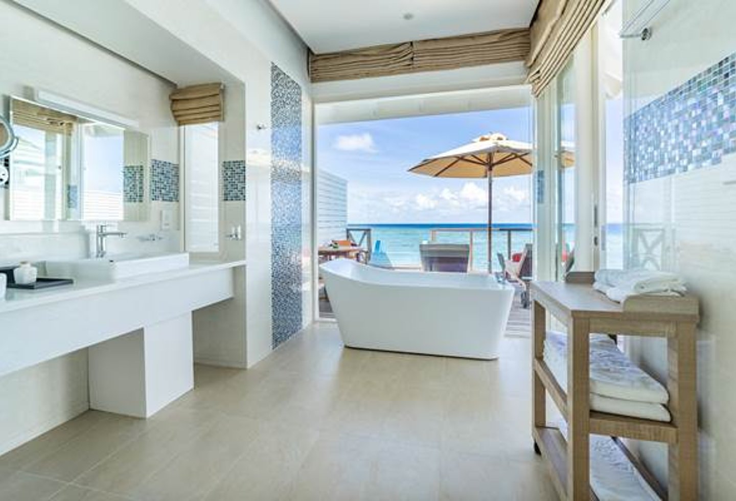 sehr helles Badezimmer, freistehende Wanne an der Fensterfront zur Terrasse mit Blick auf das Meer