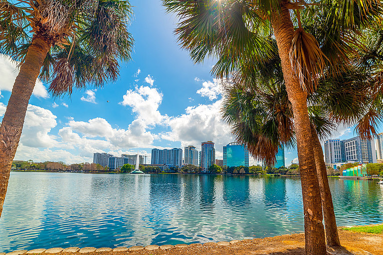 Blick über türkisblaues Wasser auf Palmen, Skyline und sonnige Küste in Florida.
