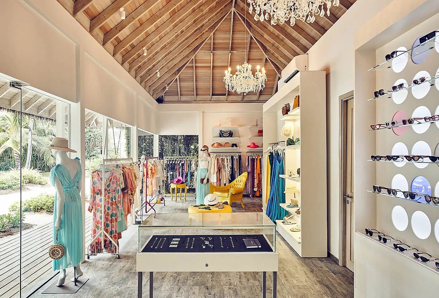 Heller Boutique-Innenraum mit Verkaufstheke, Dekoration und offenem Reetdach.