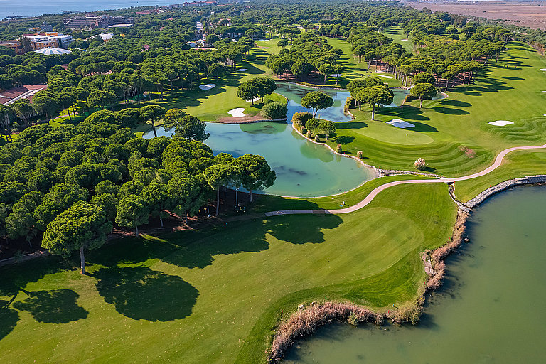 Golfplatz in Belek mit gepflegten Fairways, Wasserflächen und dichter Vegetation.