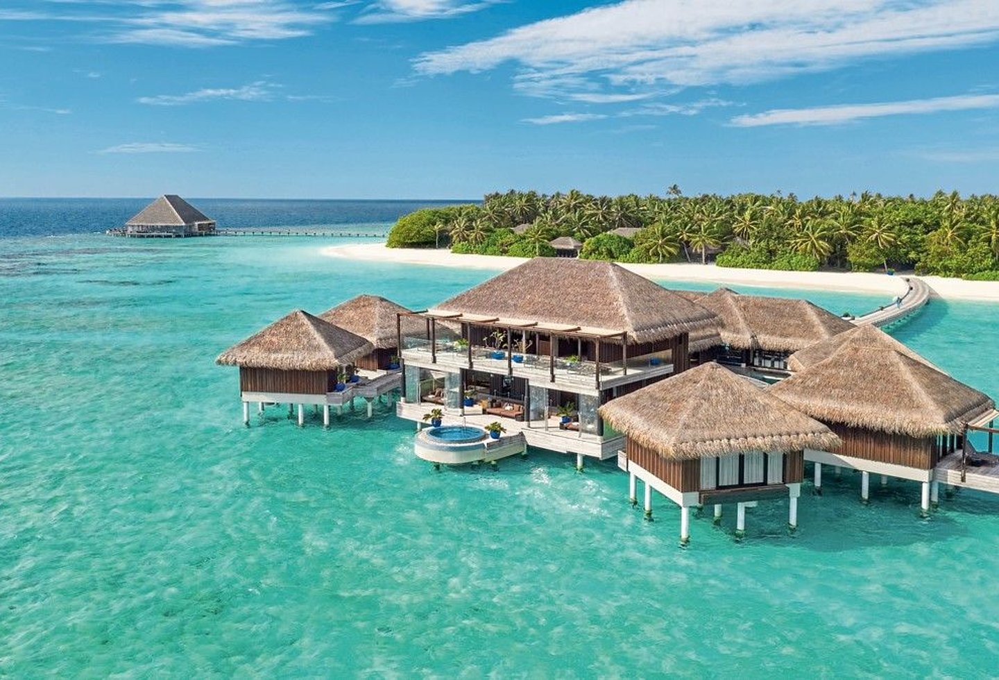 Luftaufnahme der exklusiven Insel, umgeben von türkisfarbenem Wasser.