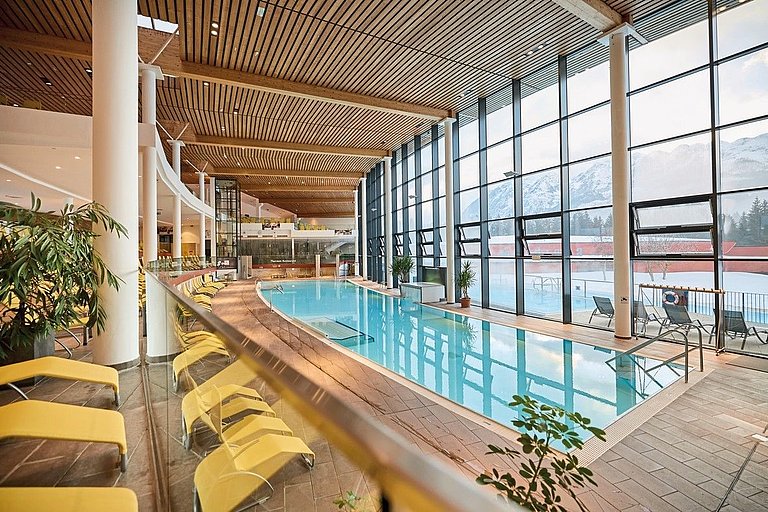 Blick in den Innenpoolbereich der Aldiana Therme, mit gelben Liegen.