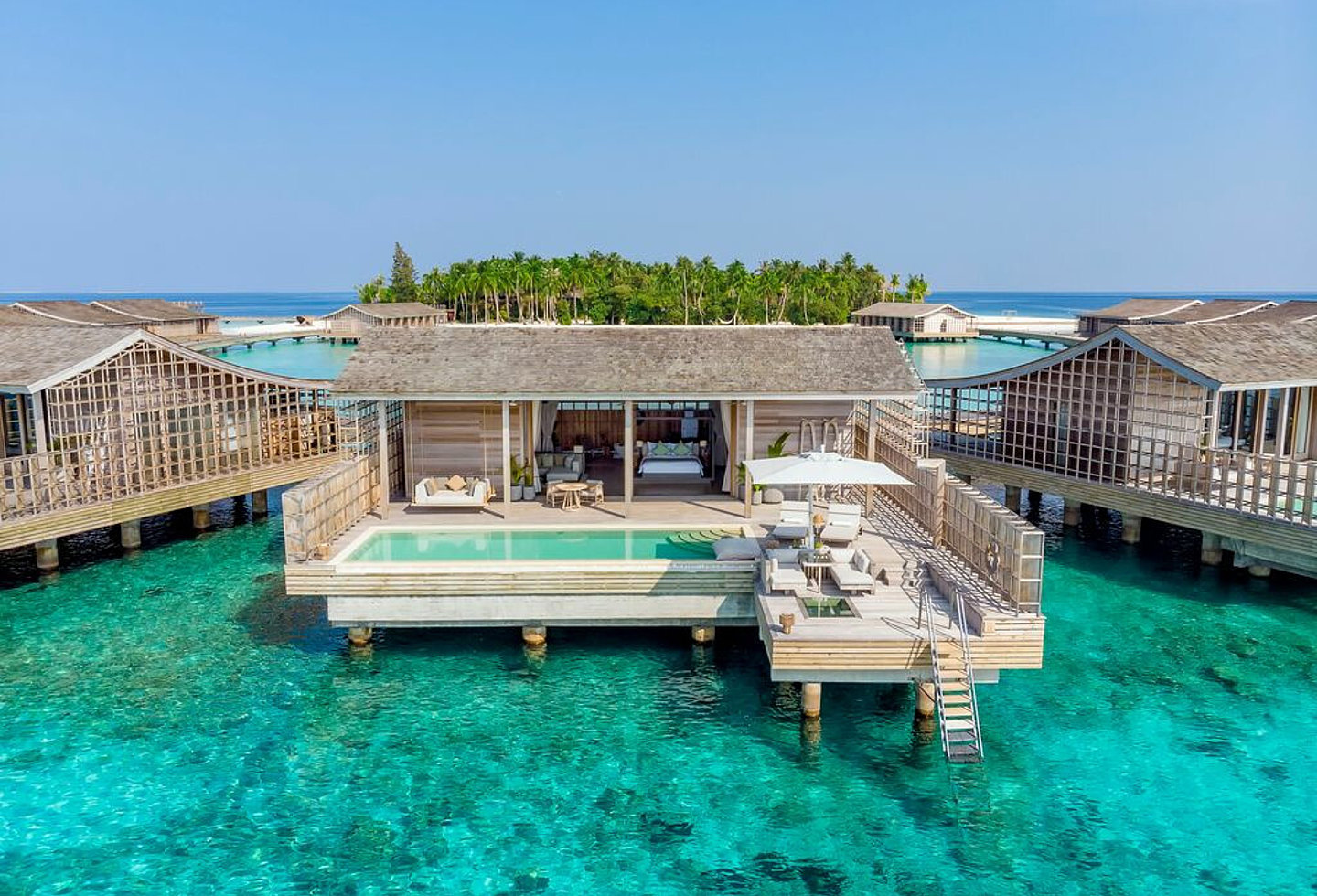 Blick vom Meer auf Terrasse einer Wasservilla, privater Pool, Stiege ins Meer, Liegen auf der Terrasse, Blick aufs Bett im Schlafraum
