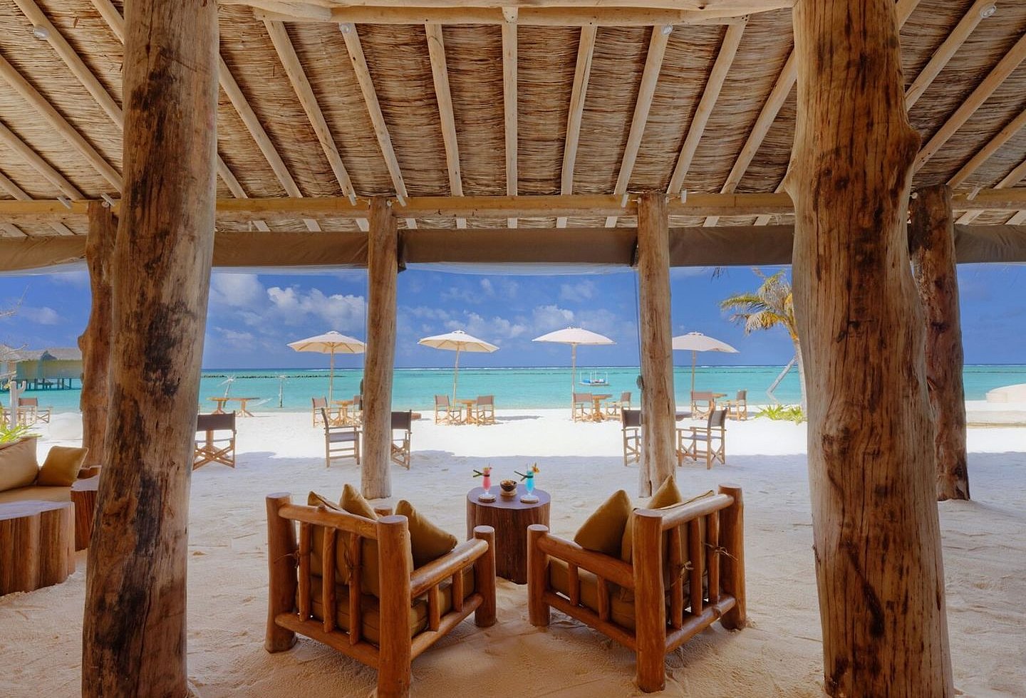 Holzpavillon mit Meerblick und gemütlichen Sitzmöglichkeiten im Resort.