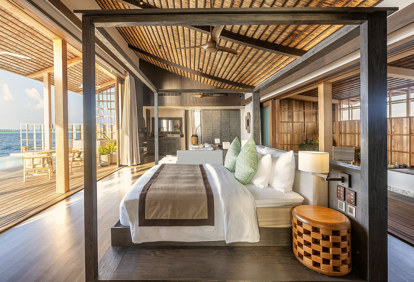 Schlafraum mit großer Fensterfront zur Terrasse hin, Sitzmöglichkeiten und Pool direkt über dem Meer