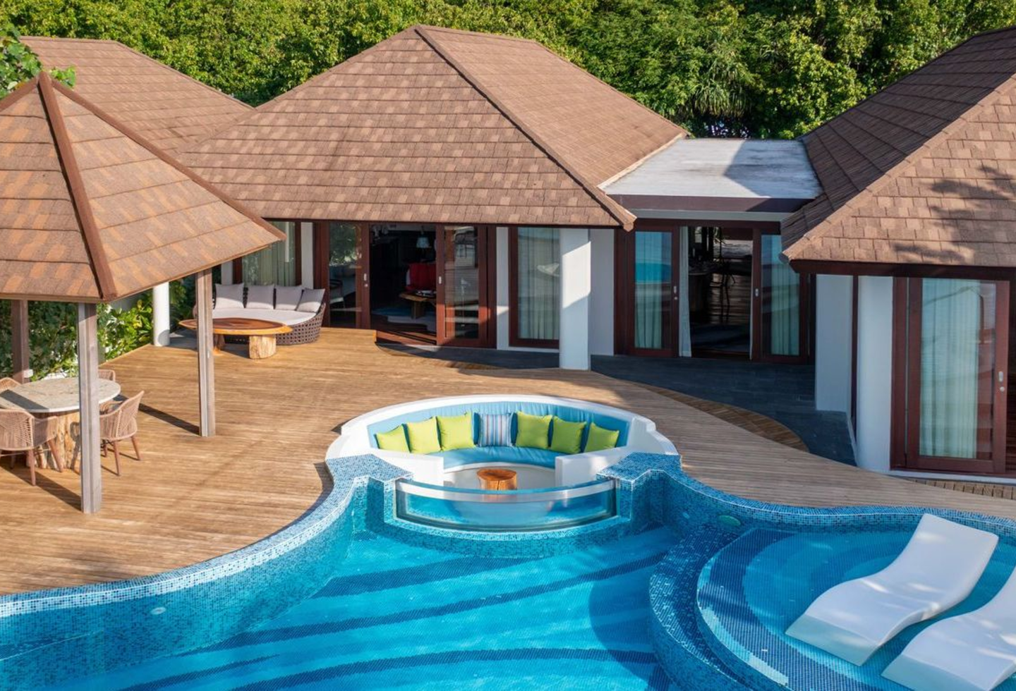 Tropische Villen mit Strohdächern, privatem Pool und Liegen in sonniger Lage.