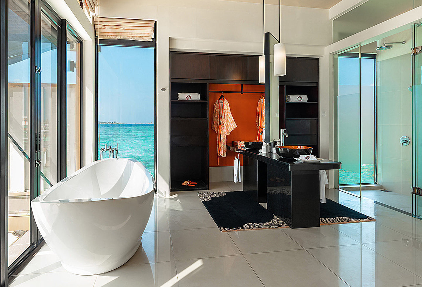 Modernes Bad mit freistehender Wanne, Doppelwaschbecken und Blick aufs Meer.