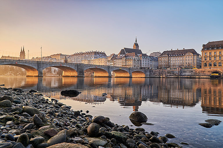 Hafen mit Booten und Altstadt am Wasser, gespiegelt im ruhigen Abendlicht.