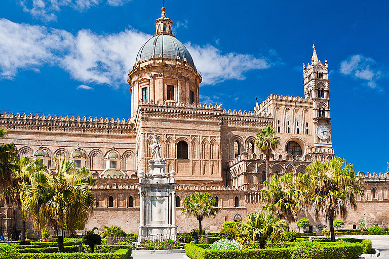 Historische Kathedrale von Palermo mit Kuppeln, Türmen und Palmen im Innenhof.