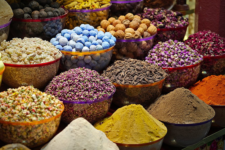 Bunte Gewürzsäcke mit Kräutern, Nüssen und Körnern auf einem orientalischen Markt.