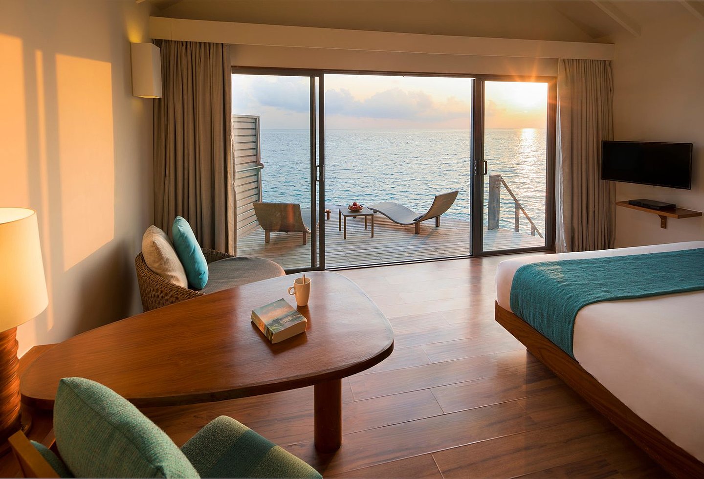 Gemütliches Zimmer einer Overwater Villa mit Meerblick auf das Meer der Malediven.