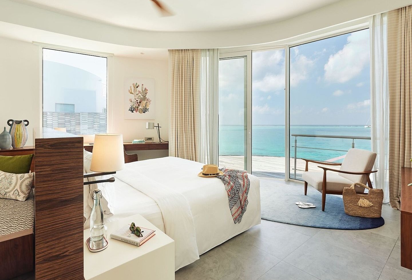 Helles Schlafzimmer mit Doppelbett, Deckenventilator und Panoramablick aufs Meer.