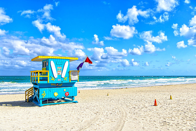 South Beach, Miami, Florida, lifeguard house in a colorful Art Deco style on cloudy blue sky and Atlantic Ocean in background, world famous travel location